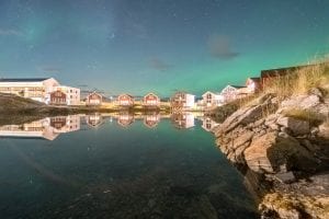 Water reflection of Northern Lights over Sommarøy Arctic Hotel building near Tromsø, Arctic Norway