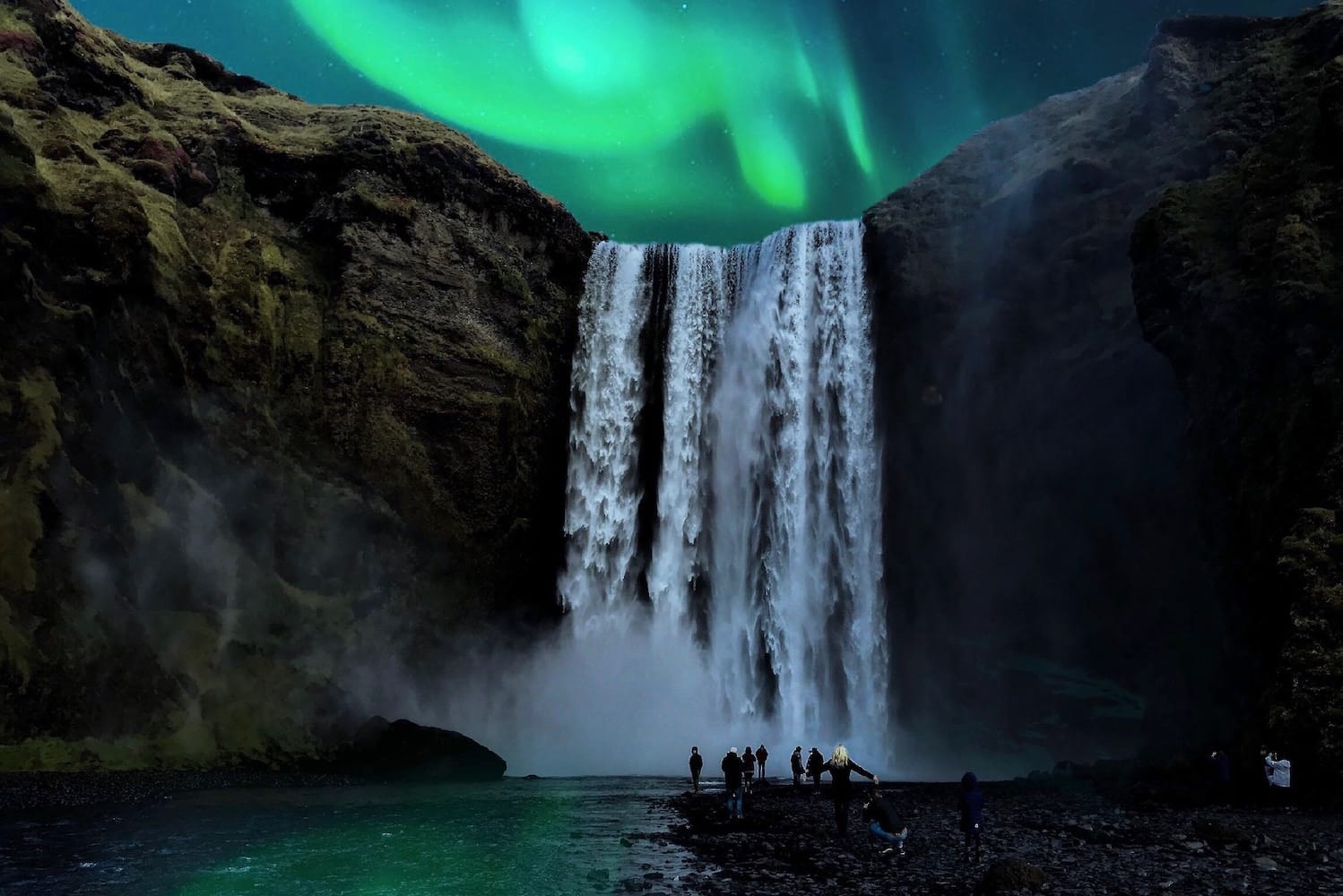 Northern Lights Aurora Borealis waterfall at night with people watching and taking photographs